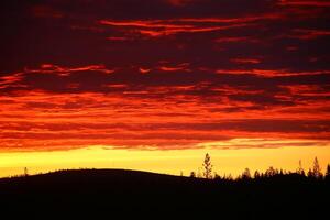Impressive cloudscape, over the silhouette of mountain and tree photo