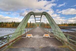 Old bridge crossing Pite river at Ljusselforsen in Lapland photo