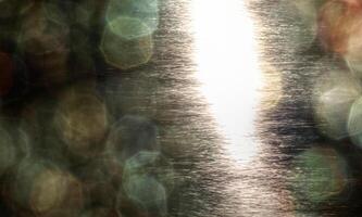 Abstract shot of sunlight reflections on the water and lens flare bokeh photo
