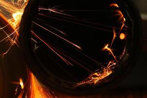 Cutting a metal pipe with angle grinder photo