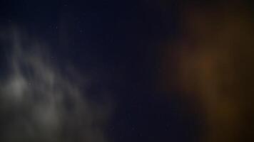 Long exposure of moving clouds on starry sky photo
