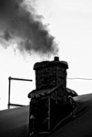Old and sooty chimney with lots of smoke photo