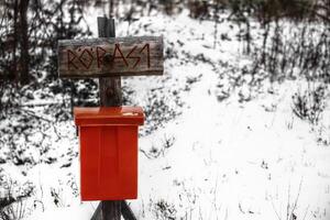 Archaic street sign with a red mailbox in snow photo
