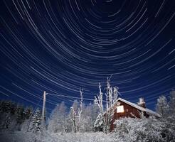 Long exposure startrail shot of Swedish house in the Forest photo