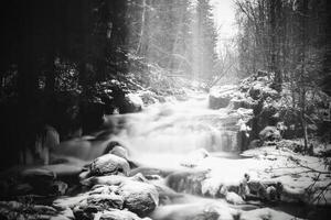 Moody long exposure shot of cascades in the small river Jaran in Bispgarden, Sweden. Light beams are coming from above photo