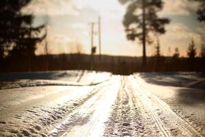 Frozen road in bright sunlight in Lapland photo