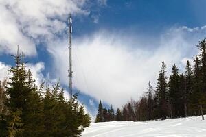 Telecommunications tower at the snowy peak of Amliden in Sweden photo