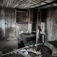 Interior of an abandoned hut with ruined stove photo