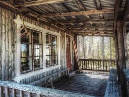 Terrace of a traditional Swedish log cabin in the forest photo