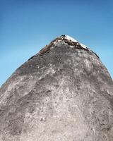 Mossy rock resembling a mountain and blue sky photo