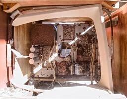 Looking into a broken television frame, revealing its inner workings photo