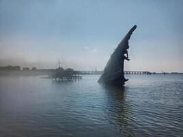 Old ship wreck in shallow water and mist photo