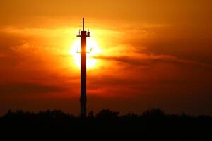 Dark scenic sunset behind a telecommunications tower photo