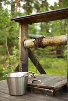 Rural wooden fountain with a metal bucket photo