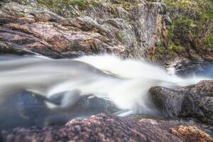 Long exposure shot of waterfall in Muddus National Park in Sweden photo
