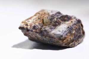 Macro of pyrite crystal fools gold in a rock, isolated on white photo