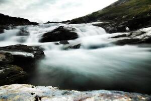 Dramatic long exposure shot of rapids and rocks photo