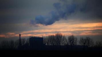 Industrial silhouette with fumes and orange sunlight photo