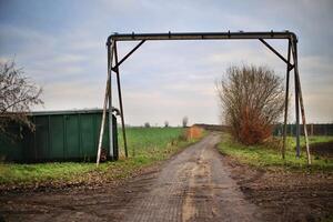 Dirty rural scene with road, pipe and container photo