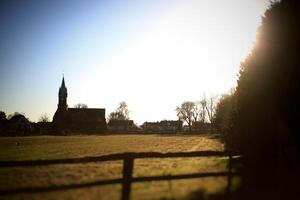 Rural backlit shot of meadow and church in Magdeburg photo