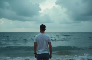 Man stand beautiful ocean shore, look into distance at blue sea waves photo