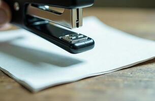 Stapler on white paper workplace in office, student desk photo