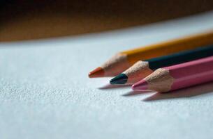 Pencils lie on white paper, art tool for hobby of drawing cabinet photo