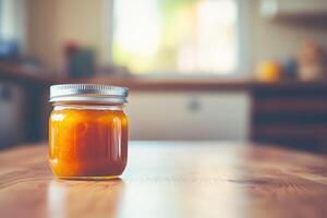 A jar of orange jam on a wooden table photo