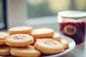 A plate of cookies on a table next to a jar of jam photo