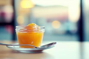 A spoon and a jar of orange juice photo