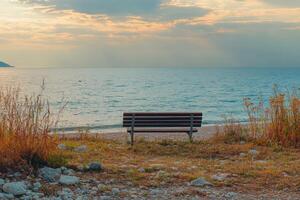 A bench sitting on a rocky beach photo