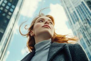 A woman looking up at the sky in front of tall buildings photo