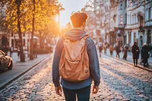 A man with a backpack walking down a street at sunset photo