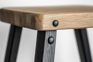 A close up of a wooden stool with black legs photo
