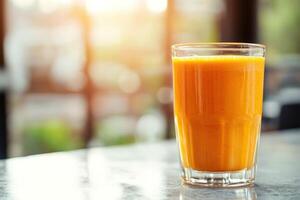 A glass of orange juice sitting on a table photo