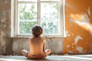 A child sitting on the floor in an old room photo