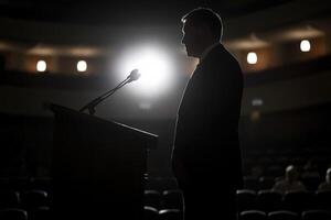 A man stands at a podium in front of a crowd photo