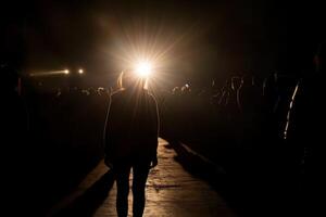 A person standing in the dark with a spotlight shining on them photo
