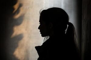 A silhouette of a woman in a dark room photo