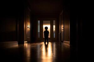 A silhouette of a child standing in a dark hallway photo