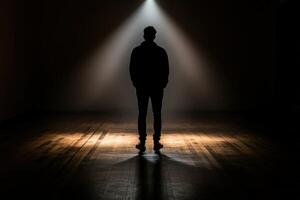 A man standing in the dark with a spotlight photo