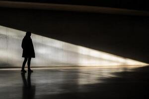 A silhouette of a person standing in a dark room photo