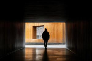 A man walking through a dark tunnel photo