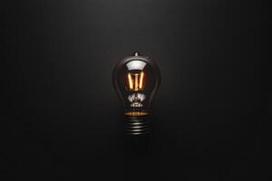 A Single Illuminated Light Bulb Against a Dark Background photo