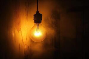Glowing Light Bulb Hanging in a Dark Room photo