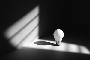 A Single Light Bulb in a Dark Room with Sun Rays Streaming Through a Window photo