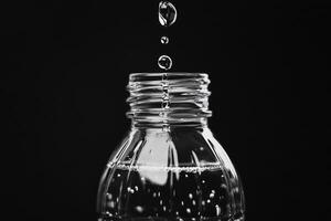 Water Droplets Falling Into a Water Bottle photo