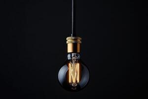 A Single Edison Bulb Hanging Against a Black Background photo