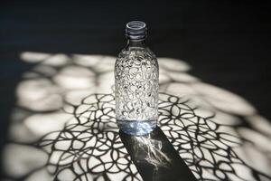 Glass Bottle Casting Geometric Shadows on a Surface photo