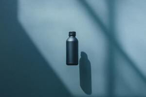 Black Bottle with Shadow on a Blue Wall photo